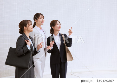 前向きな表情で同じ方向を見つめる三人の若手女性ビジネスパーソン・スーツ姿の新入社員が目標に向かって指 前向きな表情で同じ方向を見つめる三人の若手女性ビジネスパーソン・スーツ姿の新入社員が目標に向かって指 139420807