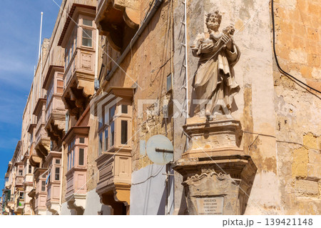 Religious statue on historic street facade in Valletta Malta 139421148
