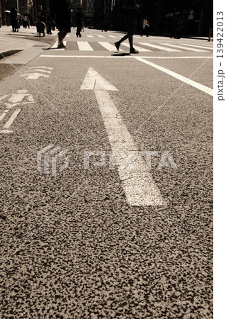 都会の進むべき道：路面の矢印と行き交う人々の足元 139422013