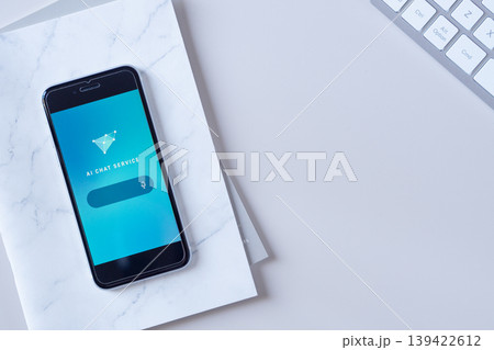 デスクに置かれたスマホに表示されたAI（人工知能）チャット画面。オリジナルイメージ。 139422612