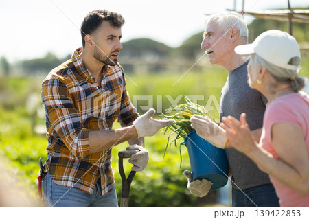 Elderly couple and young man arguing on farm field 139422853