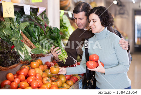 Husband and wife choose ripe tomatoes Husband and wife choose ripe tomatoes 139423054