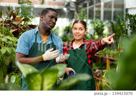 African american greenhouse owner and female worker talking 139423070