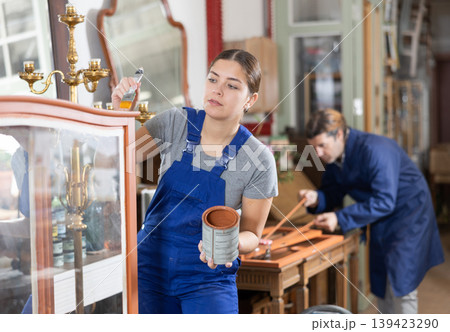 Professional furniture restorer renewing vintage chest of drawers in workshop Professional furniture restorer renewing vintage chest of drawers in workshop 139423290