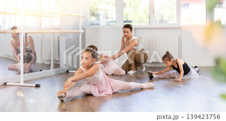 Little girls ballerinas learn to do the splits in dance class Little girls ballerinas learn to do the splits in dance class 139423756