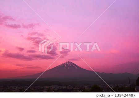 初夏の残雪がいくつもの筋となって残る富士山とバックの薄雲に朝陽が射し込み全部がピンクに染まる景色 139424497