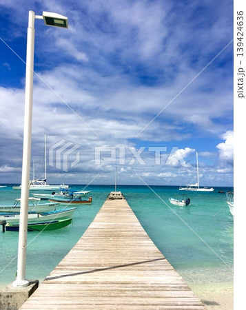 Bright tropical wooden pier with turquoise sea and dramatic blue cloudy sky, vibrant travel destination background 139424636