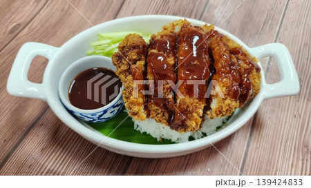 Japanese Tonkatsu Crispy Breaded Pork Cutlet Served Over White Rice with Savory Sauce 139424833