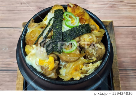 Traditional Japanese Oyakodon Bowl with Chicken, Egg, and Onions on Wooden Table 139424836