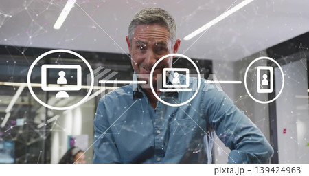 Leaning mature adult man interacting with holographic interface in modern office, network graphics Leaning mature adult man interacting with holographic interface in modern office, network graphics 139424963
