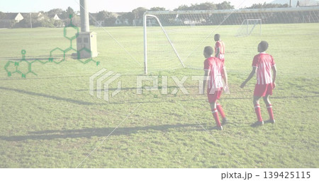 Walking four soccer players crossing grass at park toward metal goal near utility pole, copy space Walking four soccer players crossing grass at park toward metal goal near utility pole, copy space 139425115