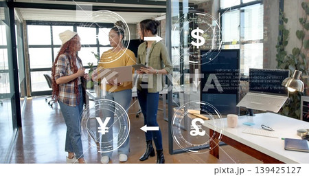 Three women in modern glass office discussing financial tech ideas, with laptop currency overlays Three women in modern glass office discussing financial tech ideas, with laptop currency overlays 139425127