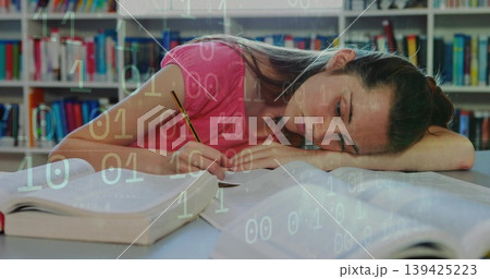 Studying teenage student writing in notebook at library table, with textbooks pencil binary overlay 139425223