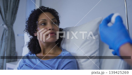 Patient wearing gown lying on bed receiving injection in ward, with syringe, pillows, IV stand Patient wearing gown lying on bed receiving injection in ward, with syringe, pillows, IV stand 139425269