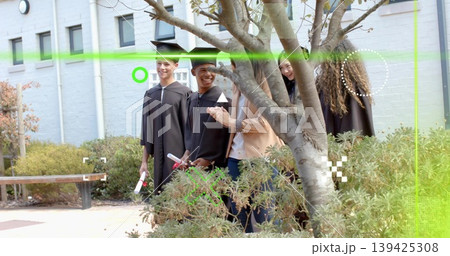 Smiling students and mentor celebrating in courtyard, with black gowns mortarboards diplomas 139425308