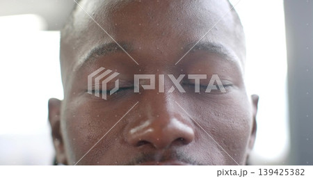 Displaying adult male face occupying frame under diffused window light, highlighting skin texture 139425382