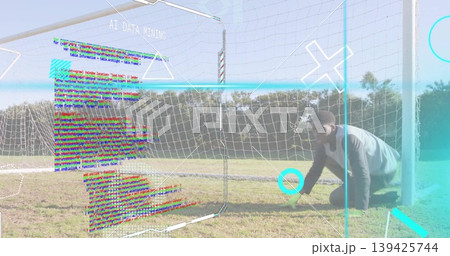 Kneeling athlete wearing sportswear at soccer goal net showing AI DATA MINING overlays, copy space 139425744