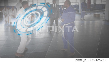 Sparring duo wearing gis and white belts throwing kicks and punches in dojo, with mats, windows 139425750