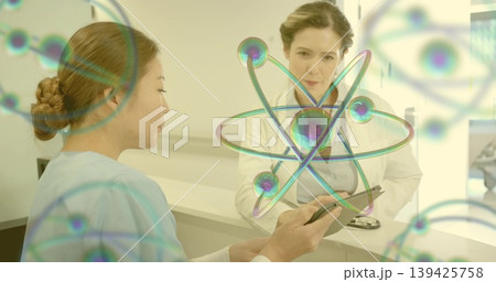 Medical duo in scrubs and lab coat examining 3D atomic data at desk, with tablet, stethoscope Medical duo in scrubs and lab coat examining 3D atomic data at desk, with tablet, stethoscope 139425758