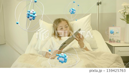 Holding tablet, child patient wearing gown resting in hospital bed, with molecular overlays Holding tablet, child patient wearing gown resting in hospital bed, with molecular overlays 139425763