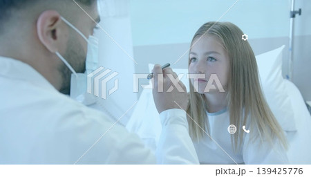Examining doctor shining penlight into patient wearing hospital gown on hospital bed, copy space Examining doctor shining penlight into patient wearing hospital gown on hospital bed, copy space 139425776