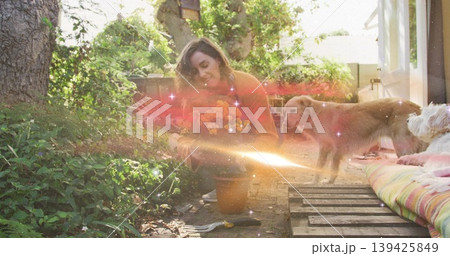 Kneeling woman planting orange marigolds from clay pot on path in backyard, with hand trowel Kneeling woman planting orange marigolds from clay pot on path in backyard, with hand trowel 139425849