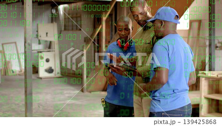 Examining three workmen in work shirts studying tablet in woodshop, with headphones, copy space Examining three workmen in work shirts studying tablet in woodshop, with headphones, copy space 139425868