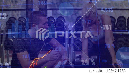 Displaying overlay trainer guiding client lifting dumbbell at bench by rack in gym, with tablet Displaying overlay trainer guiding client lifting dumbbell at bench by rack in gym, with tablet 139425983