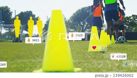 Dominating foreground, bright yellow cone leading drill on grassy pitch, mannequins, bibs, overlays 139426002