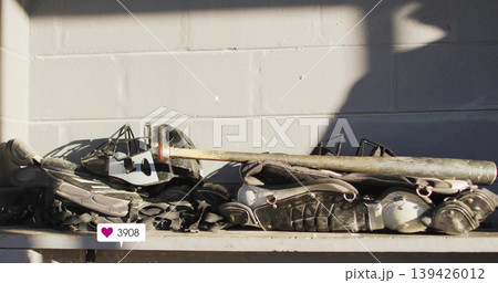 Displaying stacked catchers gear on bench against cinderblock wall, with worn bat and sticker 3908 139426012