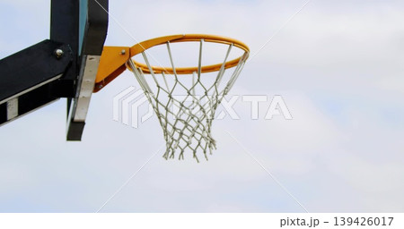 Showing basketball hoop with orange rim and white net at outdoor court left, copy space 139426017
