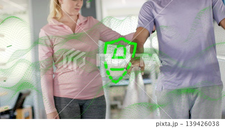 Guiding therapist helping pair in sportswear along parallel rail at rehab gym green graphic overlay Guiding therapist helping pair in sportswear along parallel rail at rehab gym green graphic overlay 139426038