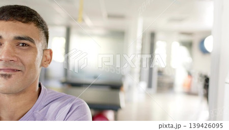 Facing male in light purple crewneck, occupying left in fitness studio with red ball, copy space Facing male in light purple crewneck, occupying left in fitness studio with red ball, copy space 139426095