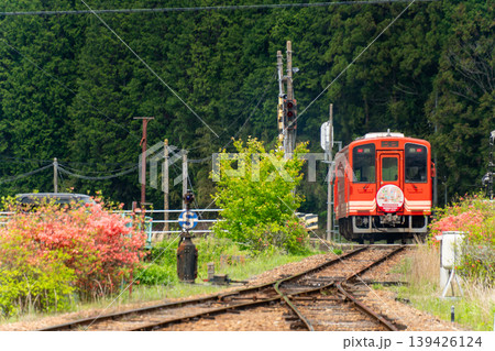 明智鉄道40周年記念ヘッドマーク列車が山間を走る風景 139426124