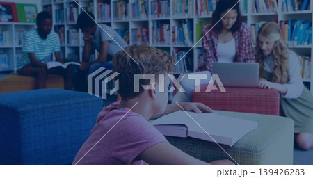 Resting boy student reading textbook on green ottoman in library, with bookshelves and ottomans 139426283