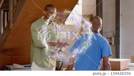 Observing two technicians examining glowing portal ring inside workshop area, with wooden staircase Observing two technicians examining glowing portal ring inside workshop area, with wooden staircase 139426350
