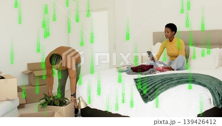 Lifting potted plant and lamp, couple unpacking moving boxes in bedroom, with smartphone Lifting potted plant and lamp, couple unpacking moving boxes in bedroom, with smartphone 139426412