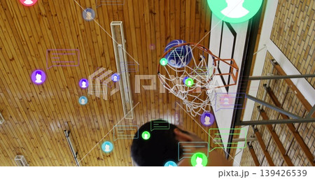 Shooting man raising hands toward rim in gym, basketball passing through net, icons, copy space Shooting man raising hands toward rim in gym, basketball passing through net, icons, copy space 139426539