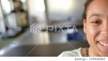 Smiling woman sitting by long tables in communal room, wearing light top and chain, copy space Smiling woman sitting by long tables in communal room, wearing light top and chain, copy space 139426862