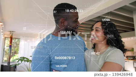 Laughing couple wearing blue knit sweater and grey top standing in open home, showing AR overlays 139426948