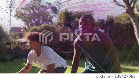 Crouching two men training in grassy lawn, wearing white shirt dark tank, magenta streak artifacts 139427068