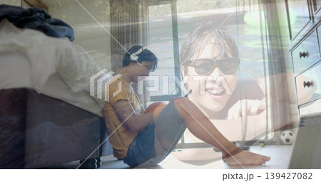 Sitting overlaid man wearing mustard tee denim shorts holding orange ball in bedroom with headset Sitting overlaid man wearing mustard tee denim shorts holding orange ball in bedroom with headset 139427082