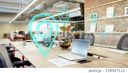Featuring silver laptop centered on table in coworking space, sitting open with papers and AR pins 139427112