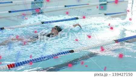 Backstroking swimmer in swimsuit, cap, goggles in lap pool with lane dividers splashing Backstroking swimmer in swimsuit, cap, goggles in lap pool with lane dividers splashing 139427150