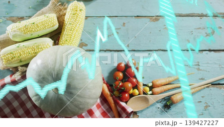 Sitting pale-green pumpkin on checkered-cloth on worn-blue-planks, with corn-cobs and ECG-waveform 139427227