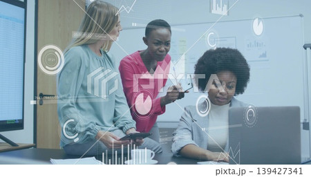 Reviewing three women in blazers leaning over laptop at meeting room, showing data overlays Reviewing three women in blazers leaning over laptop at meeting room, showing data overlays 139427341