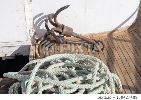 Nautical equipment on wooden deck with rope and vintage anchor 139427489