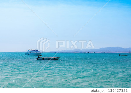 Tranquil seascape with boats on turquoise waters and distant mountains 139427521