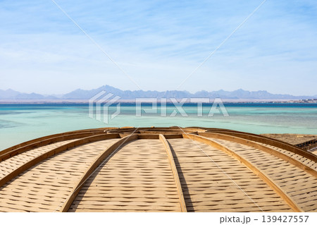 Serene coastal view with wooden dome and distant mountains in low resolution 139427557