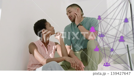 Talking couple leaning on stair landing, woman pink blouse, man teal tee, handrail, purple overlay Talking couple leaning on stair landing, woman pink blouse, man teal tee, handrail, purple overlay 139427647